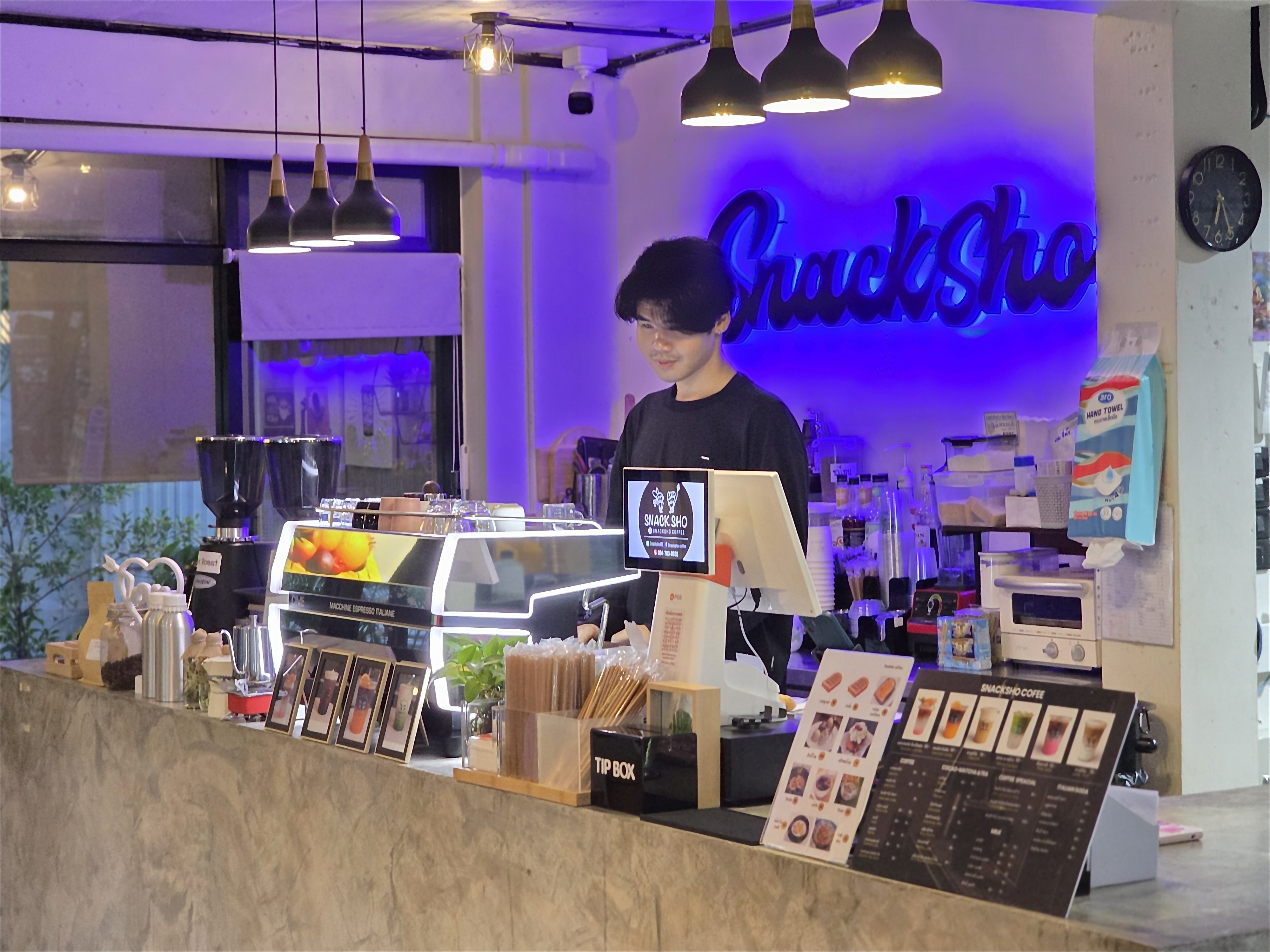 Barista at the counter under neon
